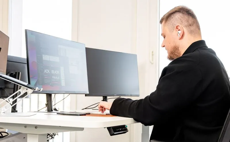 A graphic designer from Rügamer & Steiner is working on a large screen in the office