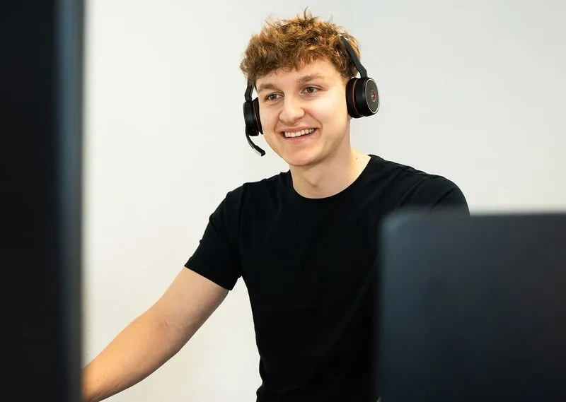 Ein Mitarbeiter von Rügamer & Steiner im Gespräch mit Headset am Arbeitsplatz